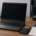 โน้ตบุ๊ก Windows จอดำพร้อมอุปกรณ์สำรองข้อมูลบนโต๊ะตรวจซ่อม