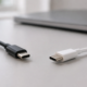 ภาพสร้างหัวสาย USB-C สีดำและสีขาวที่มีรูปทรงคล้ายกันวางแยกบนโต๊ะ